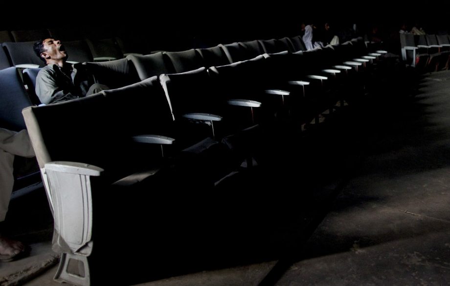 A man yawns in the cinema
