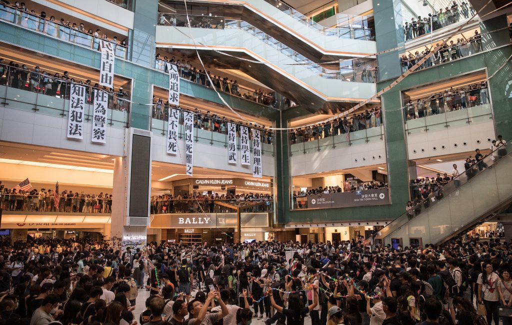 Pro-democracy protesters sing songs and chant slogans during a rally inside a shopping mall in Shatin on September 22, 2019